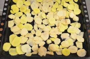 Противень смазать растительным маслом, выложить нарезанный картофель